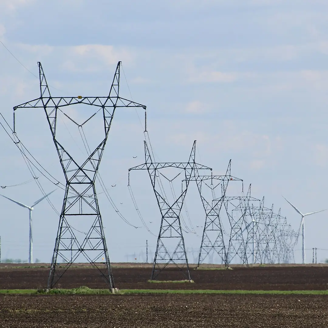 Mehrere Strommasten vor offenem Himmel, stehen für präzise Messungen und Engineering-Leistungen im Bereich Energienetze.